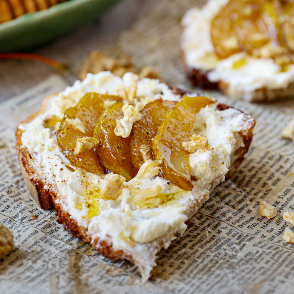 Opečený chléb s čerstvým kozím sýrem, karamelizovanými hruškami, medem a ořechy